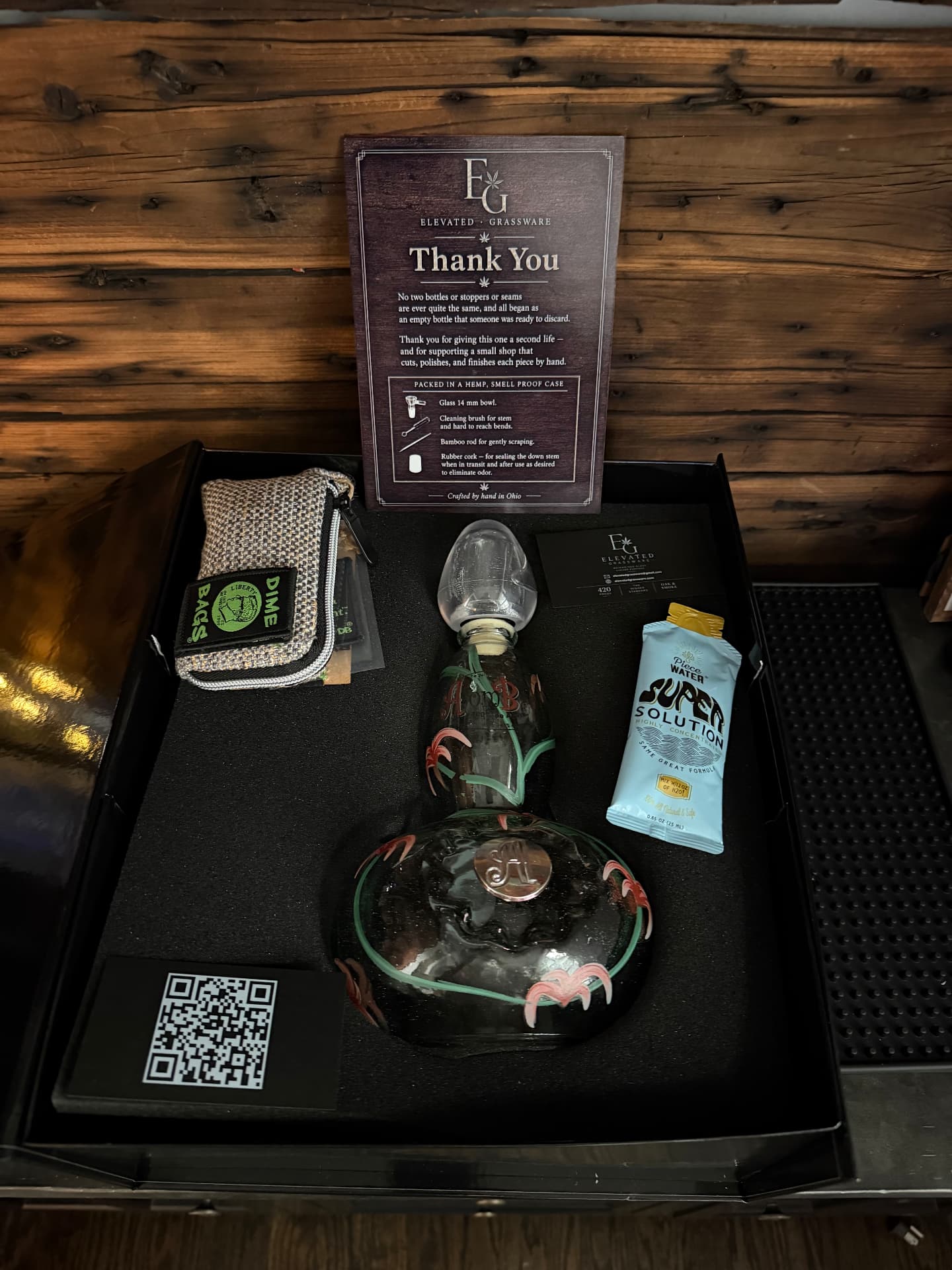 Elevated Grassware presentation box opened, with decanter water pipe, hemp case, cleaning kit and thank-you card